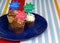Three chocolate frosted cupcakes on a blue plate with