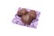 Three chocolate heart candy in puple foil on white background