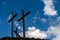 Three Christian crosses on blue sky with clouds