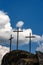 Three Christian crosses on blue sky with clouds