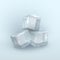 Three chunks of frozen water in shape of cube on light blue background. Rectangular cold blocks.