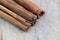 Three cinnamon sticks on a chopping board