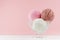 Three classic ice cream balls - strawberry, chocolate, creamy in elegant transparent glass bowl on white wood table, pastel pink.