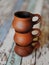 Three clay ceramic cups on top of each other. Handmade pottery. Wooden background