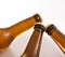 Three closed beer bottle necks on white table with fresh water drops