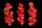 Three clusters of red currants on a black background. Full depth of field.