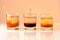 Three cocktails on orange background