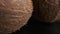 Three coconuts spinning on a black background close-up