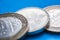 Three coins close-up on a blue background