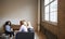 Three colleagues at a casual work meeting in a lounge area