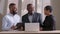 Three colleagues coworker African American woman, mature afro man boss and black ethnic young guy sitting at table with