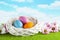 Three colored Easter eggs in the nest, pink and white flowers on grass and sky background