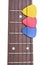 Three colored mediators on a guitar fretboard