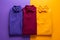 three colored polo shirts on a purple and orange background