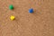 Three Colored Thumb Tacks on Cork Board