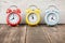 Three colorful alarm clocks