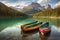 Three colorful boats or canoes on green water lake or river at national park in mountains