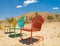 Three Colorful Chairs Forgotten in the Desert