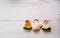 Three colorful crocheted Easter chickens against white wooden ba