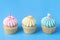 Three colorful fancy cupcake on blue