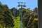 Three colorful gondolas cable cars as they transport people up and down in the Caracol Park