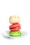 Three colorful macaroons on white saucer