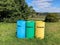 Three colorful outdoor recycling bins with inscriptions in Spanish lenguage.