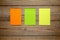 Three colorful post-it notes on wood