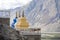 Three colorful religious stupas with mountain view.