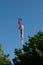 Three colorful windsocks at a metal flagpole