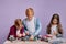 Three concentrated children assemble robots toys