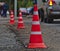 Three cone along the road. Cars are going downtown.