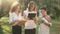 Three confident smart colleagues analyzing paperwork and e-market looking at camera smiling. Portrait of positive