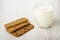 Three cookies-muesli, glass of yogurt on wooden table