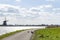 Three coots are fighting on the cycle path along the lake De Rottemeren near windmill Tweemanspolder nr 4 on a sunny and windy day