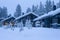 Three Cosy Wooden Houses with Christmas Tree in Front Located in Tranquil Picturesque Nordic Forest