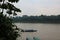 Three covered canoes on the Tambopata River edged by rainforest in Madre de Dios, Peru