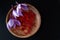 Three crocus flowers with saffron stamens on a wooden plate. Saffron stamens and flowers on a black background.