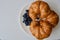 Three croissants and blue blueberries
