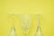 Three crystal wine glasses on a yellow background