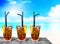 Three cuba libre exotic tasty cocktails background beach and turquoise sea