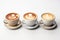 Three cups of coffee with latte art on white background