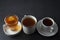 Three cups with hot tea drink on dark background, copy space. Tea time or tea brake. Autumn beverage. Toned image with tea cups