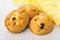 Three curd biscuits with raisin and striped yellow napkin