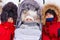 Three cute children in winter jackets and hoods with fluffy winter fur