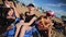 Three cute females friends joyfully sit on sandy beach sunny summer day.