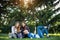 Three cute girlfriends resting the park. Young attractive girls on a green lawn talking and laughing. Concept of outdoor