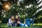Three cute girlfriends resting the park. Young attractive girls on a green lawn talking and laughing. Concept of outdoor