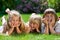 Three cute girls outdoor in the grass smiling