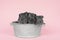 Three cute grey guinea pigs sitting next to eachother in a pewter tin bath on a pink background